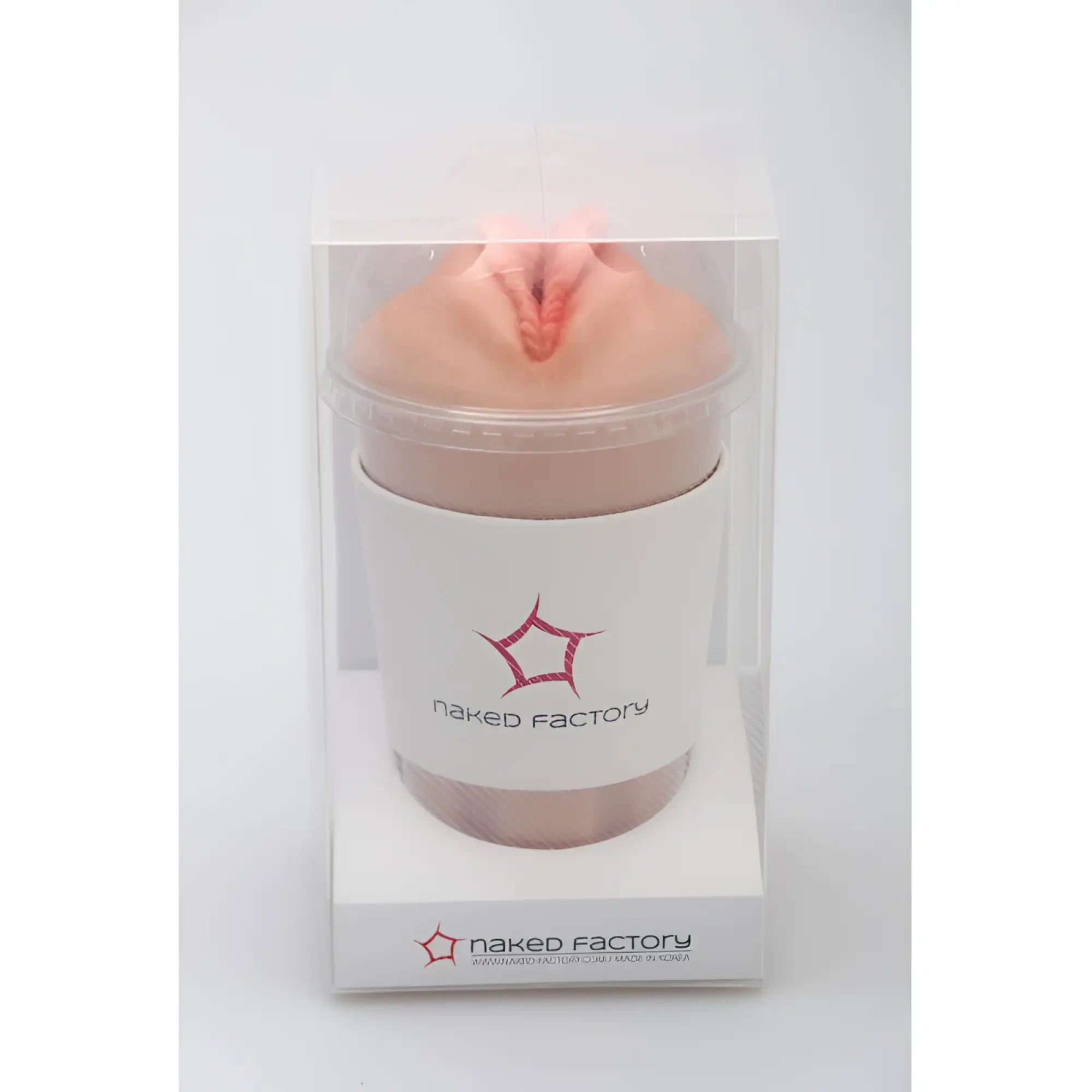 A peach-colored silicone textured naked factory pussy masturbator dani with central opening and subtle red detailing in clear packaging