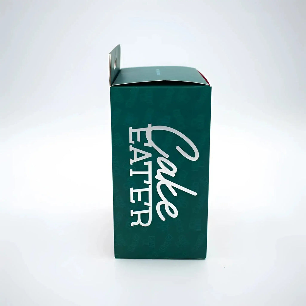 Dark green cardboard box with cake eater printed in white cursive for natalies toy box blue clit flicker stimulator