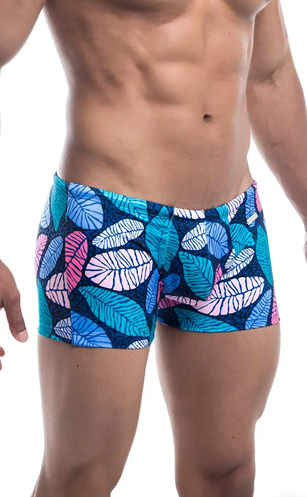 Oceanico square cut swim trunks with vibrant blue pink and teal tropical leaf pattern on dark navy base