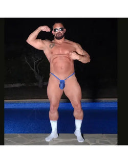 Blue ribbed G-string thong underwear by Arroyman featuring a bulge design worn by a model by a pool.