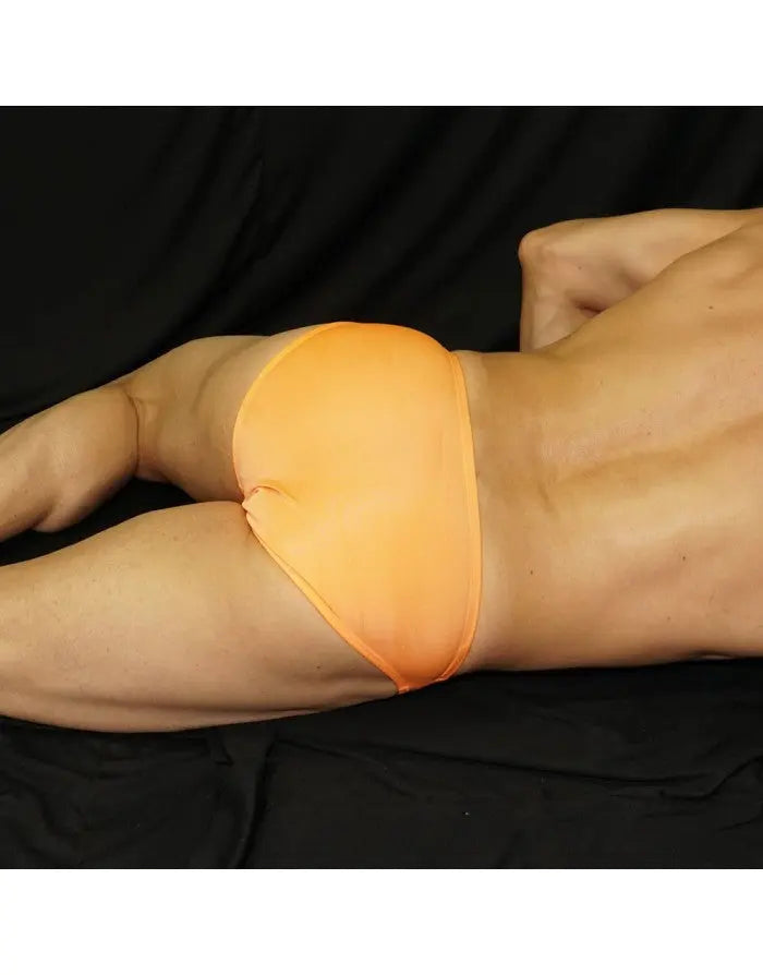 Orange bikini swimwear by Arroyman featuring a snug fit and minimal coverage shown on a model against a dark background.