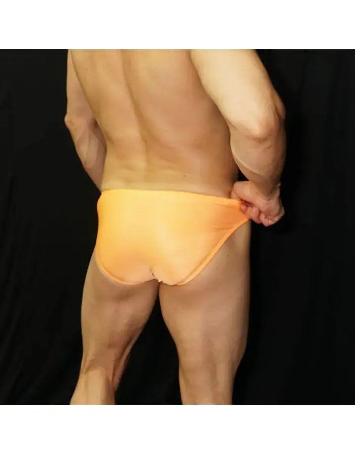 Men's orange bikini swimwear by Arroyman featuring a snug fit and smooth fabric shown from the back on a model.