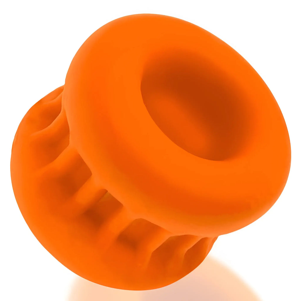 Bright orange silicone oxballs core grip squeeze ball stretcher with ribbed texture and circular opening