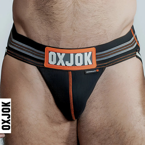Black OxBalls slingjock briefs with orange and gray striped waistband in black iron color front view