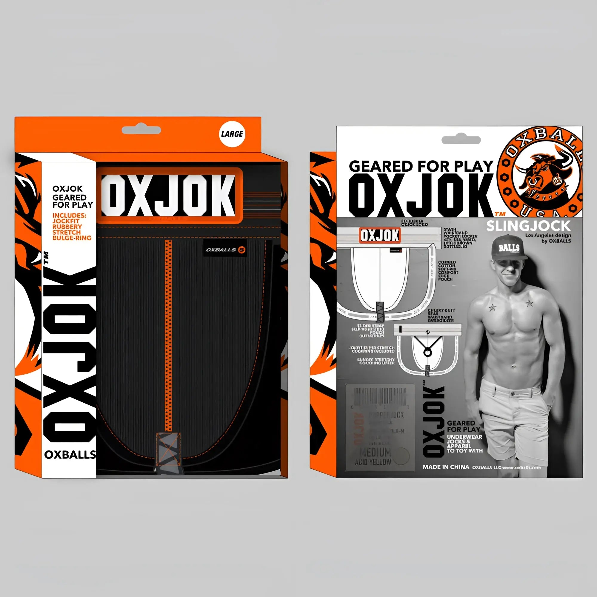 Black oxballs slingjock upthrust slider-strap jock in black iron with orange stitching and rubberized bulge-ring