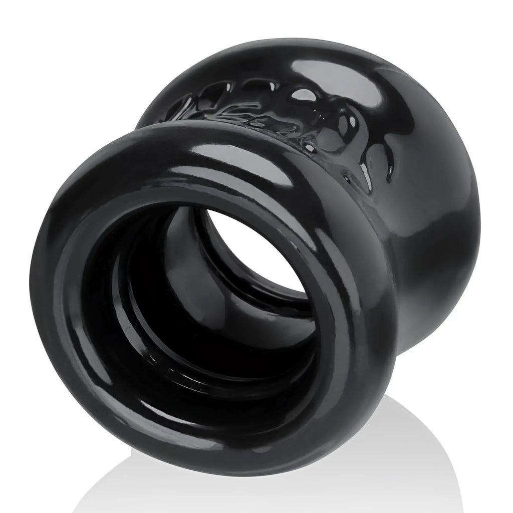 Black glossy silicone anal plug with textured skull design on rounded end oxballs squeeze ballstretcher night
