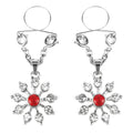 Silver snowflake-shaped nipple clamps with a central red gemstone and clear crystals.