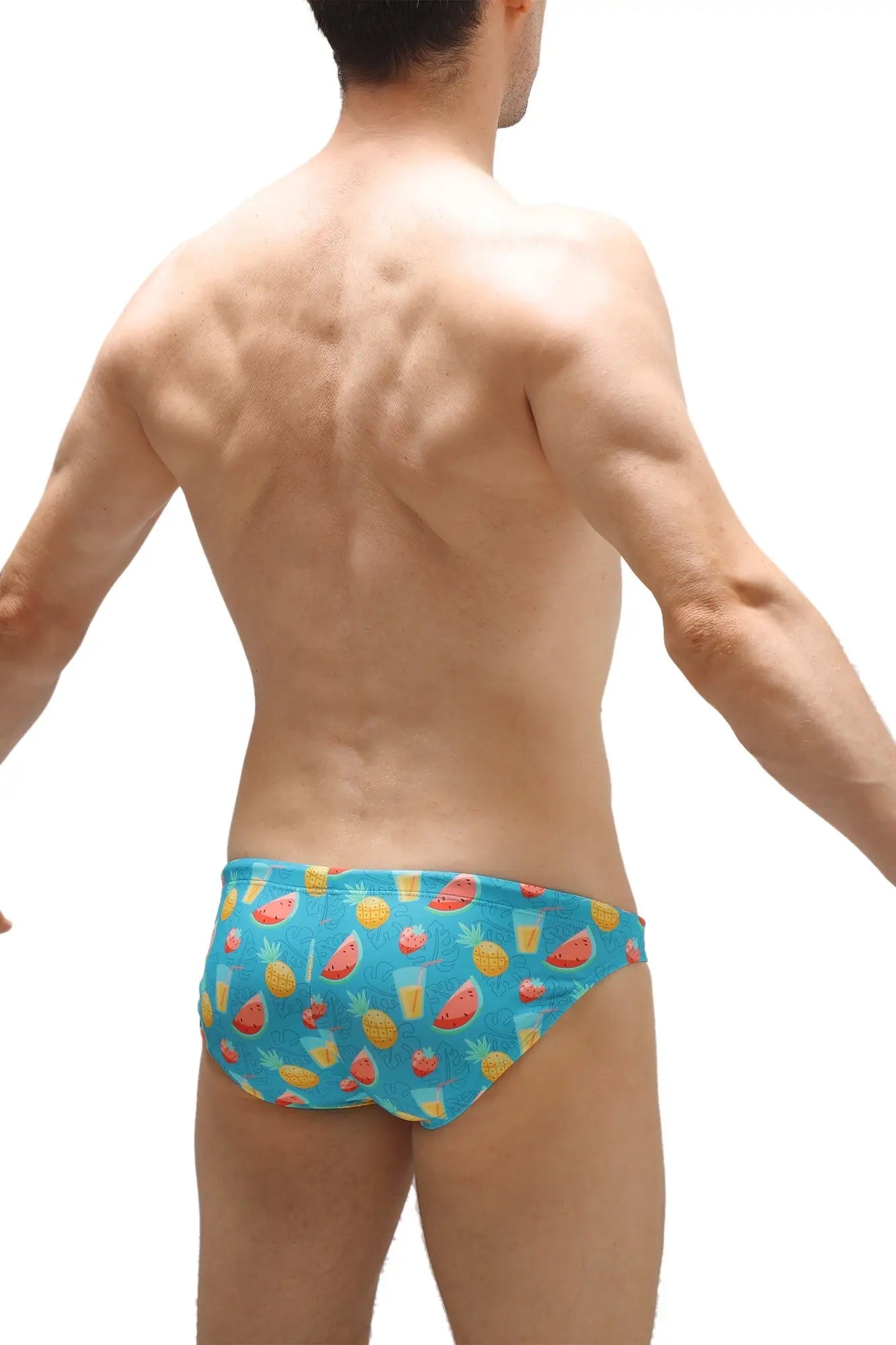 Blue swim trunks with a vibrant tropical fruit pattern featuring watermelons pineapples and juice glasses for kids
