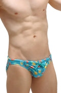 Bright blue PetitQ swim bikini Taik Punta trunks with playful pineapple watermelon and tropical drink pattern