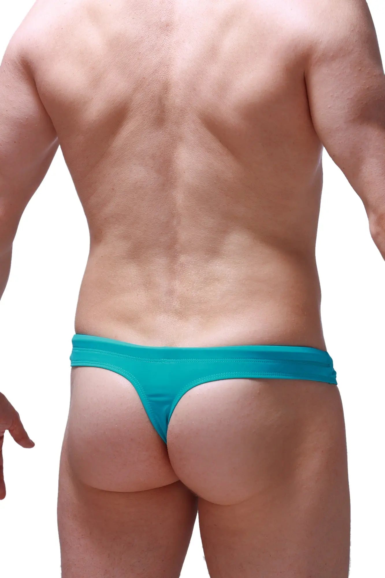 Teal-colored petitq swim thong made of stretchy fabric with snug fit and minimalistic design shown from the back side