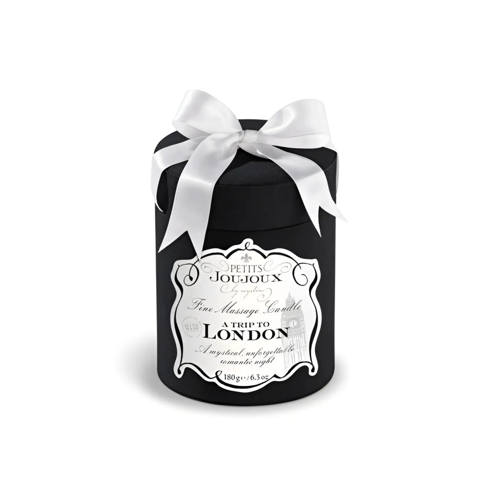 Black cylindrical Petits JouJoux A Trip to London massage candle with white satin bow and ornate silver label 190ml