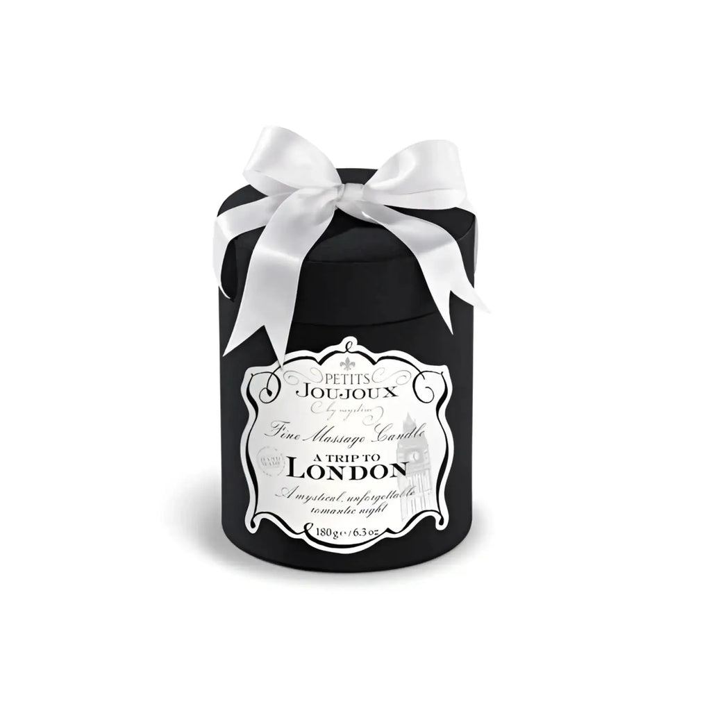 Black cylindrical Petits JouJoux A Trip to London massage candle with white satin bow and ornate silver label 190ml