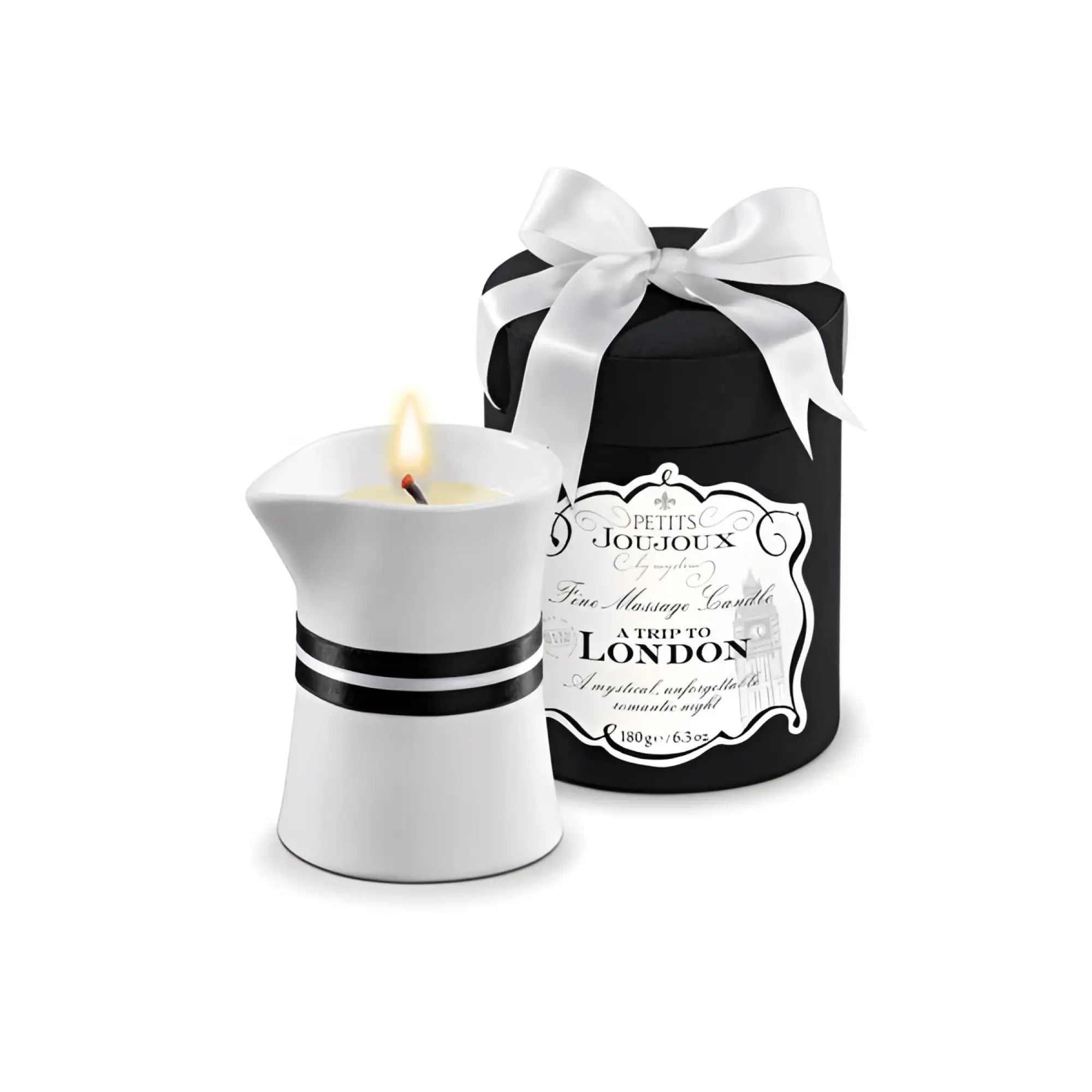 White ceramic massage candle shaped like a teapot with black stripes lit and emitting a soft glow Petits JouJoux