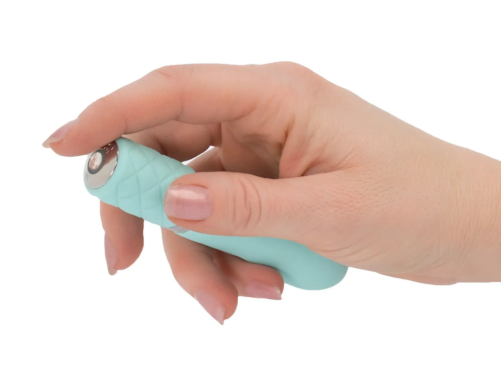 Pillow Talk flirty teal electric facial device with teal textured silicone handle and metallic button on top