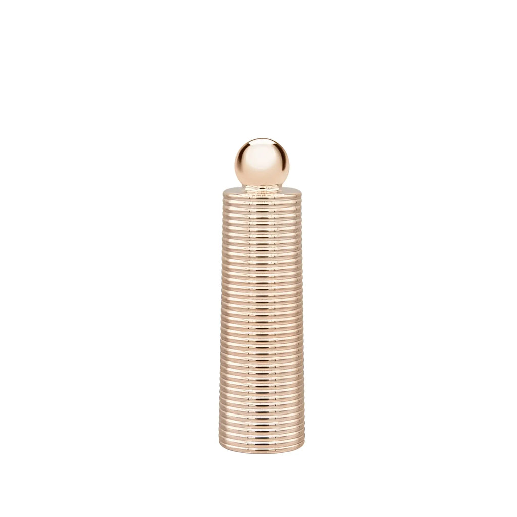 A sleek rose gold metallic ribbed cylindrical bottle with a polished spherical cap from pillow talk secrets desires massager set