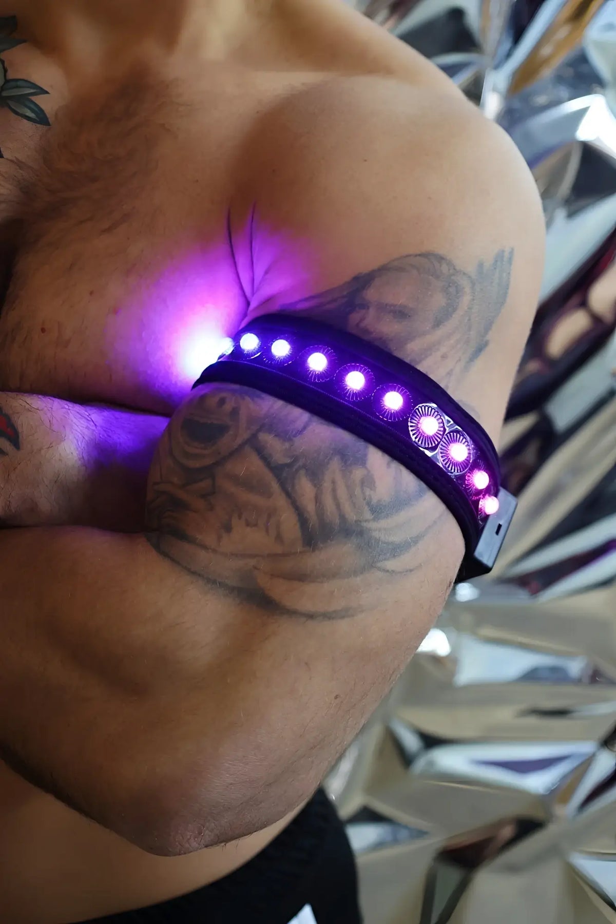Prismaglow armband purple led with circular light patterns worn on a tattooed arm highlighting its vibrant glow