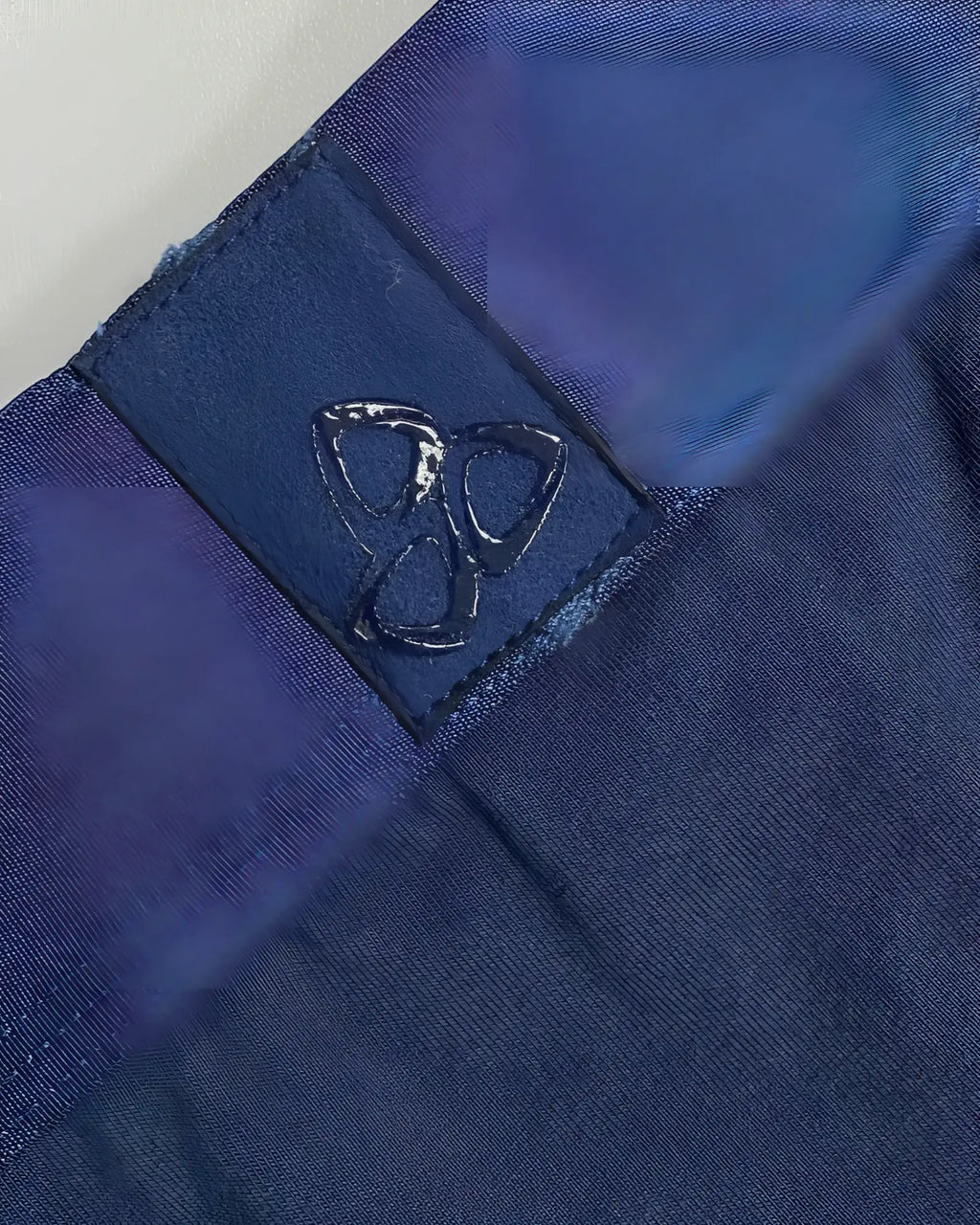 Dark blue fabric patch with a glossy embossed logo stitched onto navy ranger private structure baut4389 athlete trunks