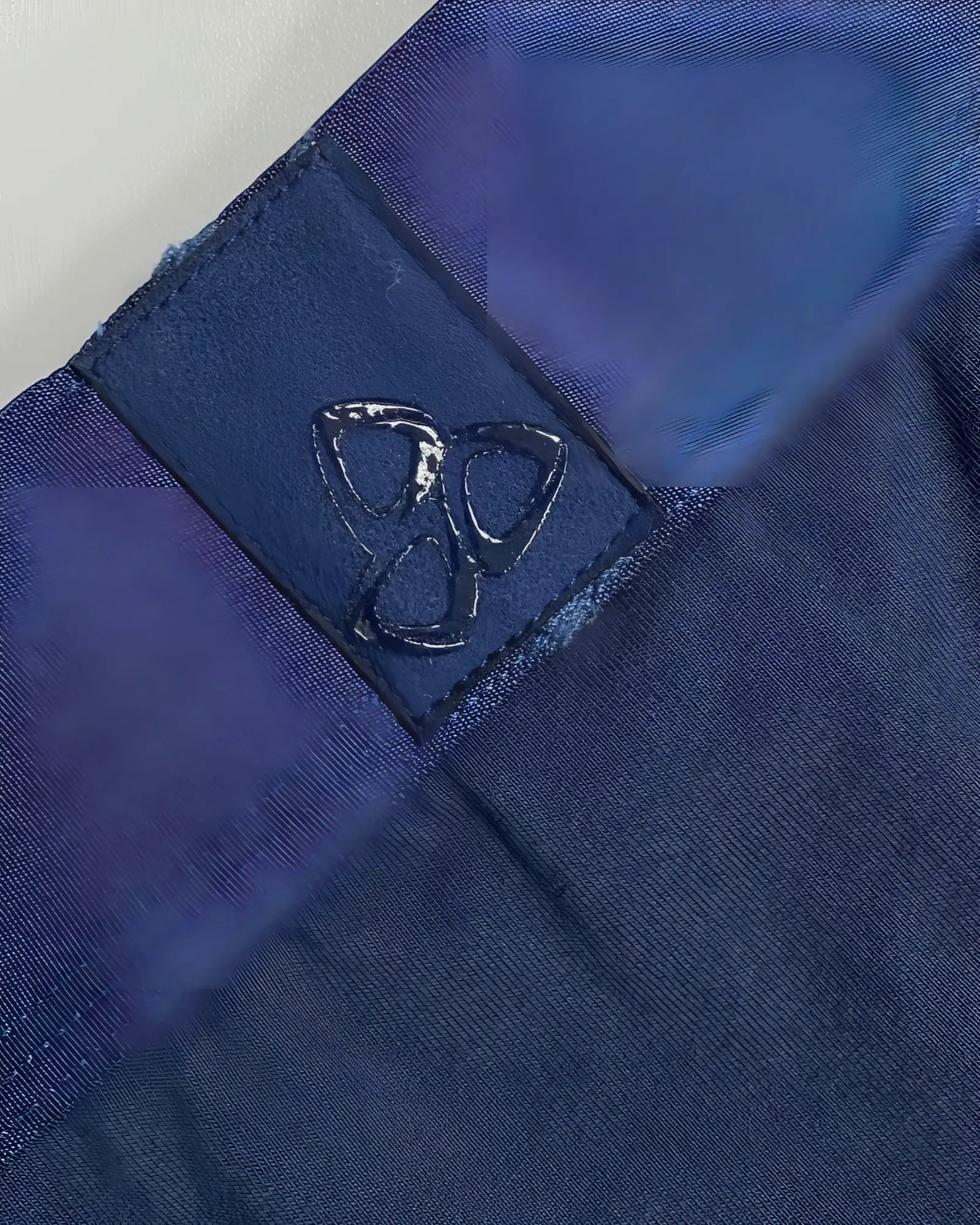 Dark blue fabric patch with a glossy embossed logo stitched onto navy ranger private structure baut4389 athlete trunks