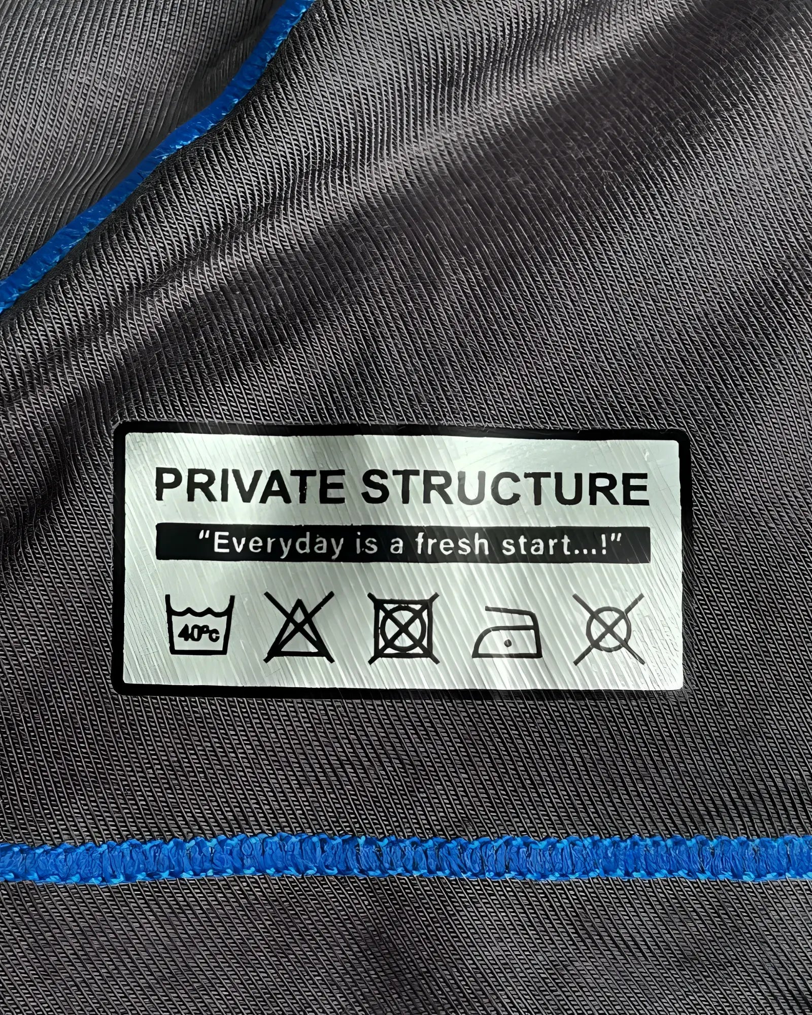 Gray fabric with blue stitching and white private structure care label on the back of epus4570 prime elysian hipster