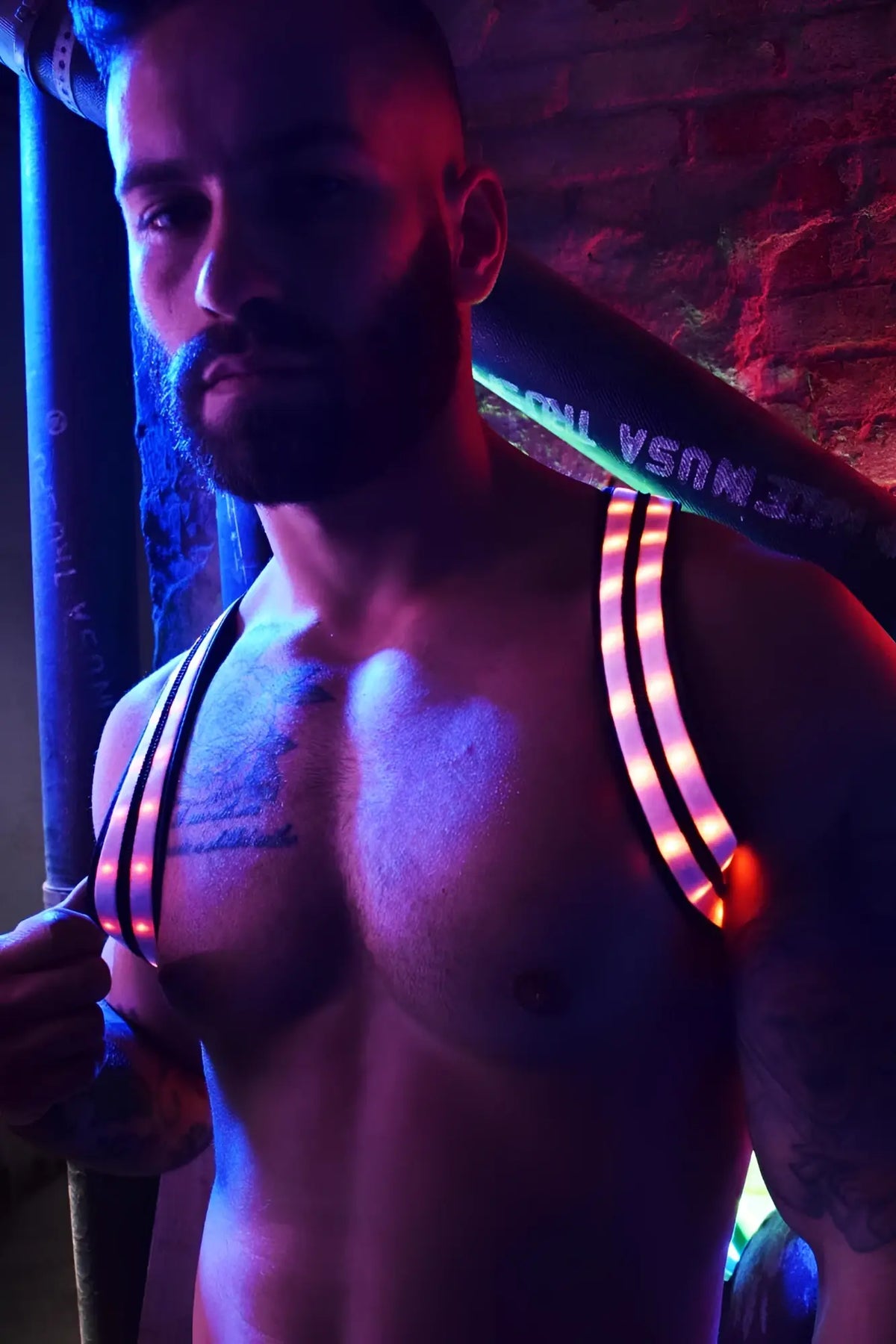 Rave shoulder harness with glowing neon led strips worn across the chest and shoulders for rave or party use