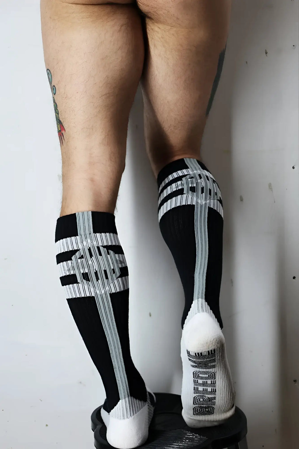 Retro Remix socks black and gray striped knee-highs with bold cross and white lettering on the heel