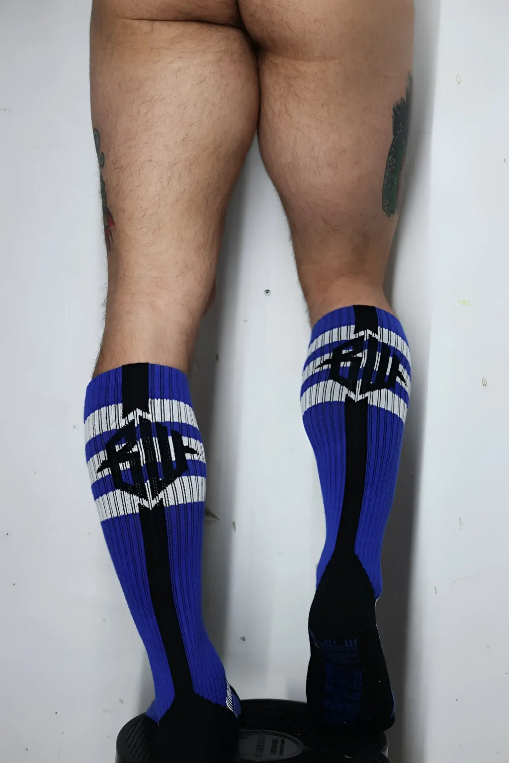 Retro remix socks feature blue and black athletic fabric with white stripes and a bold she logo in the center