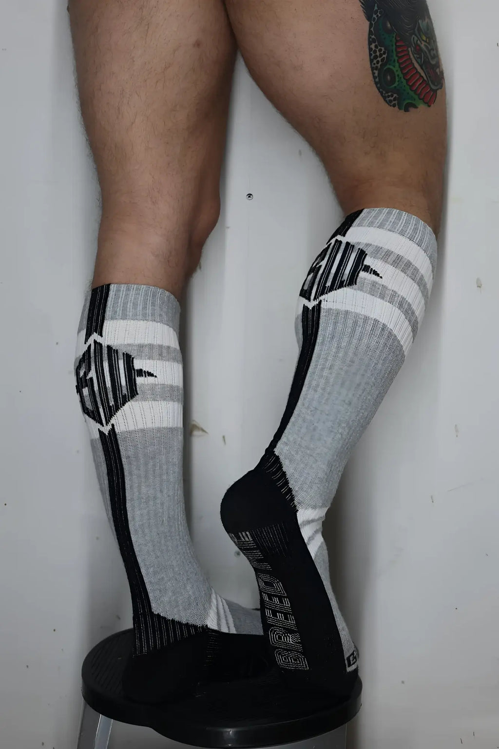 Gray and black athletic knee-high retro remix socks with striped patterns and ribbed textured design