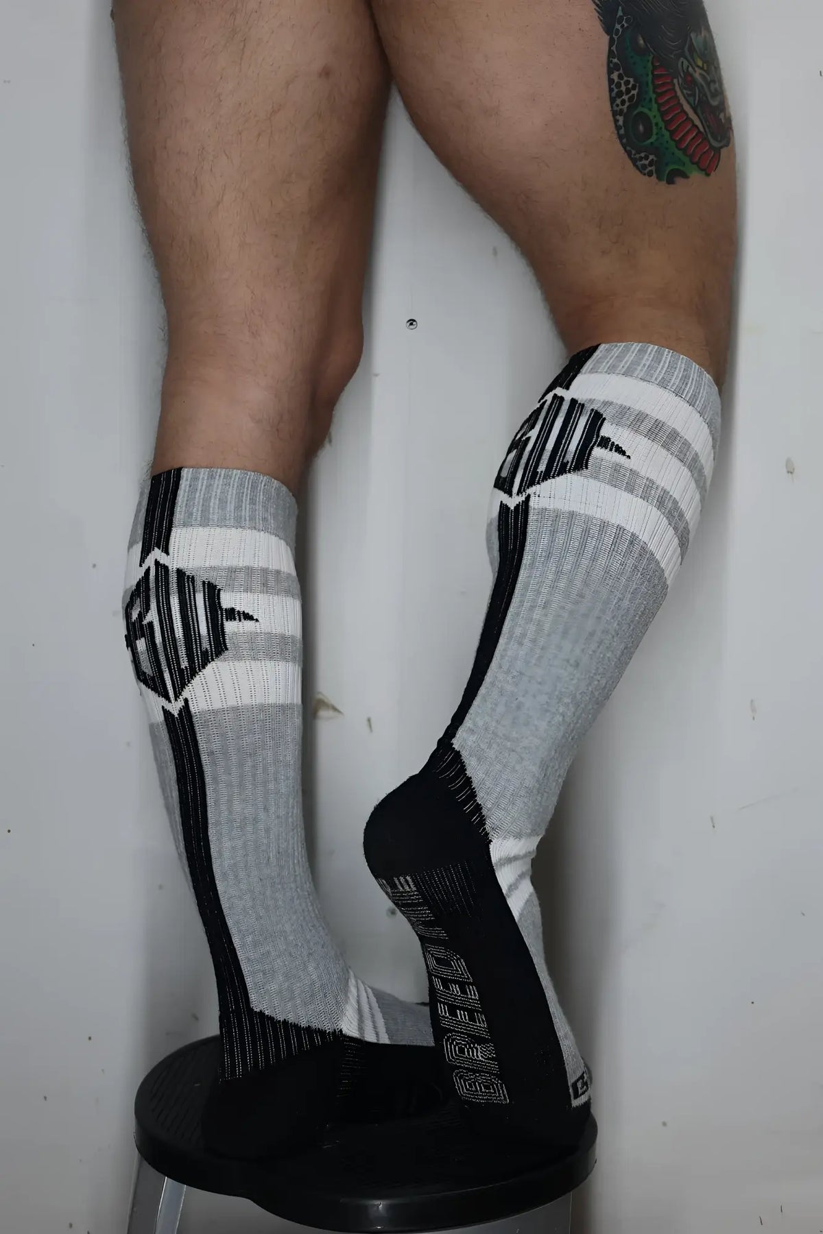Gray and black athletic knee-high retro remix socks with striped patterns and ribbed textured design