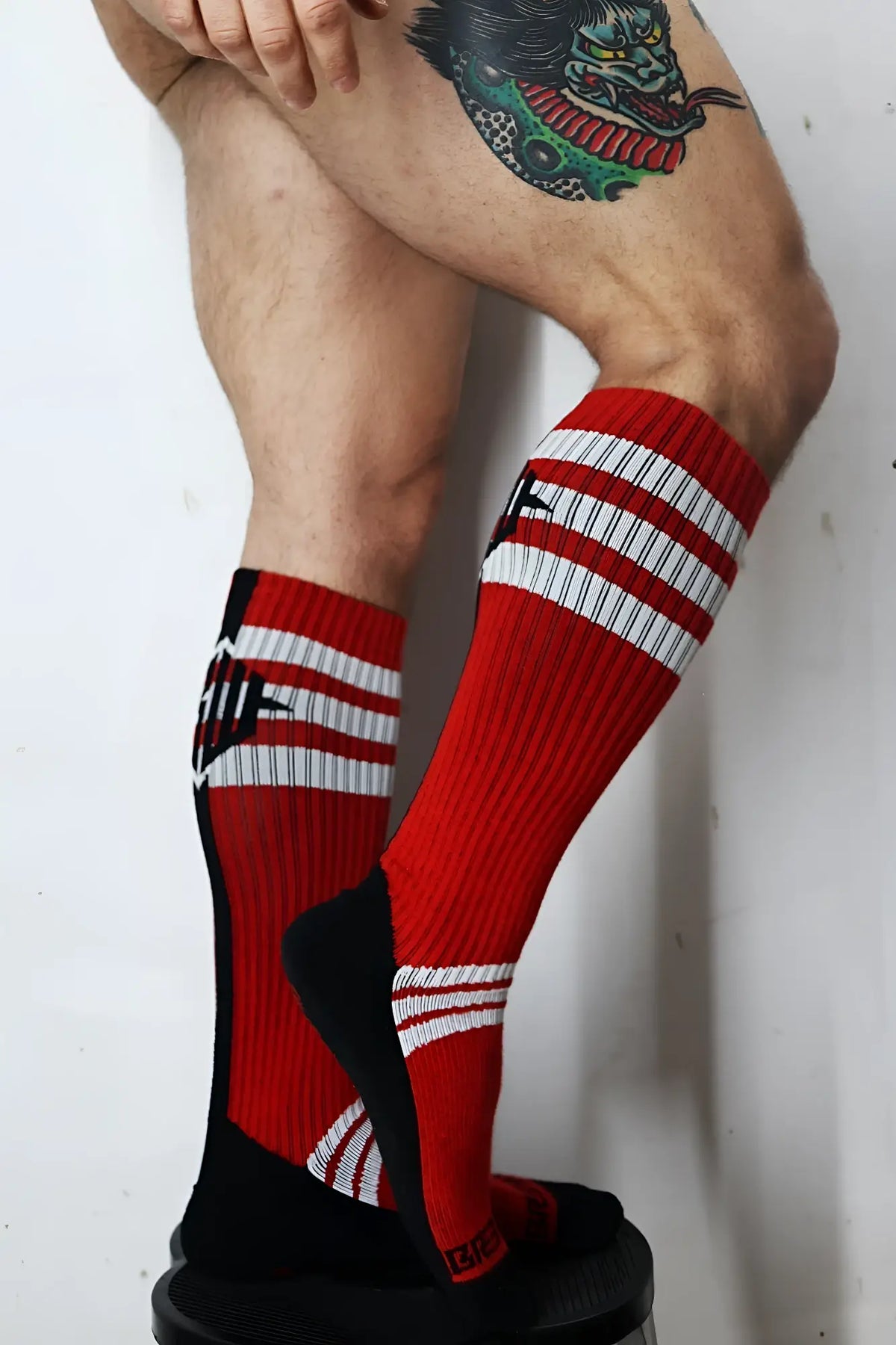 Retro remix socks with red and black colors white stripes and bold graphic design on the side for athletic use