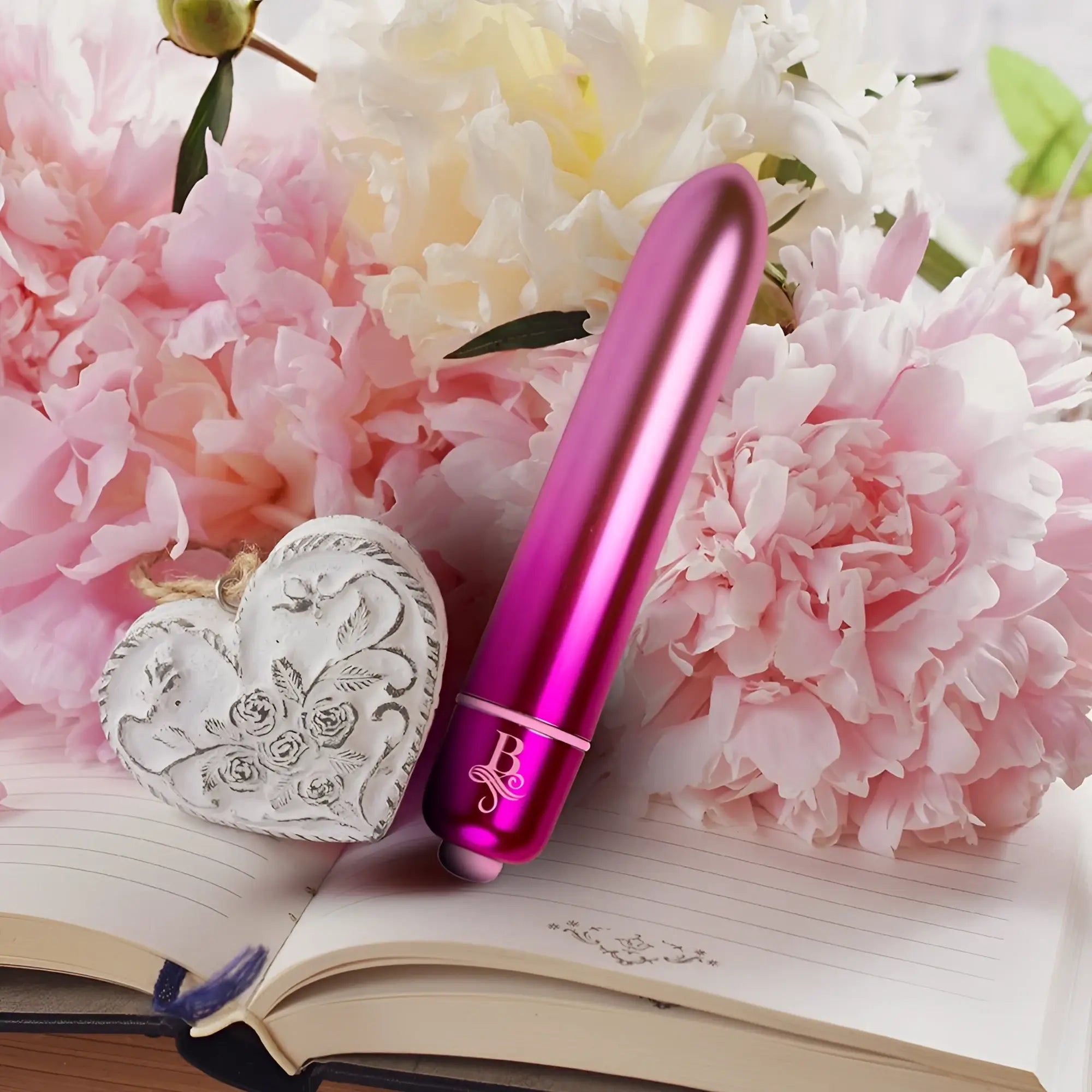 A sleek metallic pink cylindrical vibrator with a silver logo band near the base from Rocks Off Boudoir Courtesan Bullet