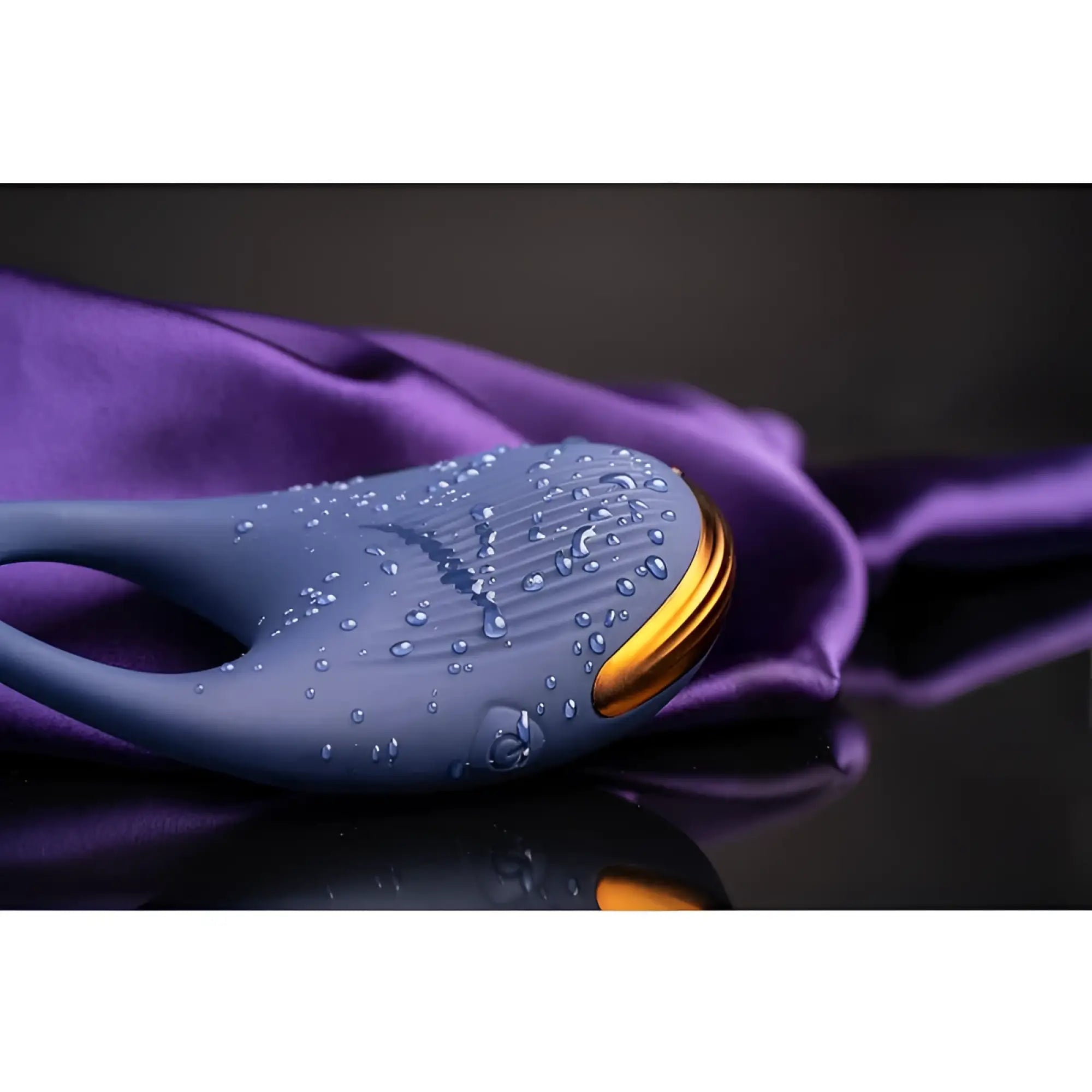 Blue whale-shaped vibrating cock ring by rocks off with gold fin and textured surface covered in water droplets