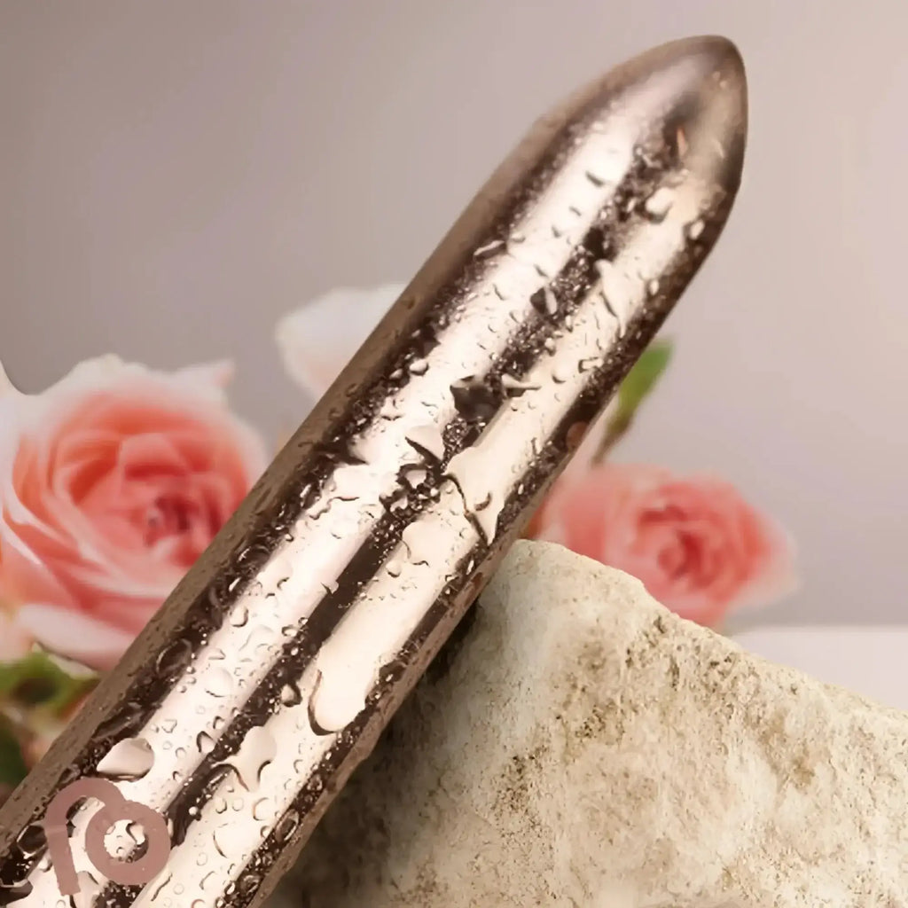 A sleek metallic silver Rocks Off Golden Rose rechargeable bullet vibrator with textured surface and water droplets