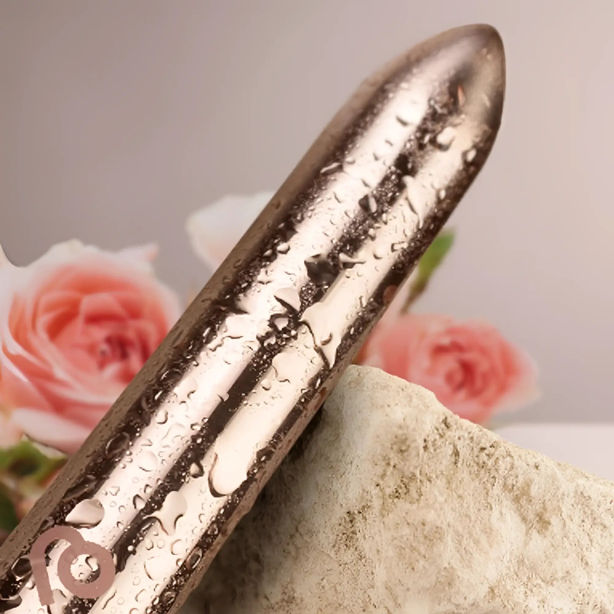 A sleek metallic silver Rocks Off Golden Rose rechargeable bullet vibrator with textured surface and water droplets
