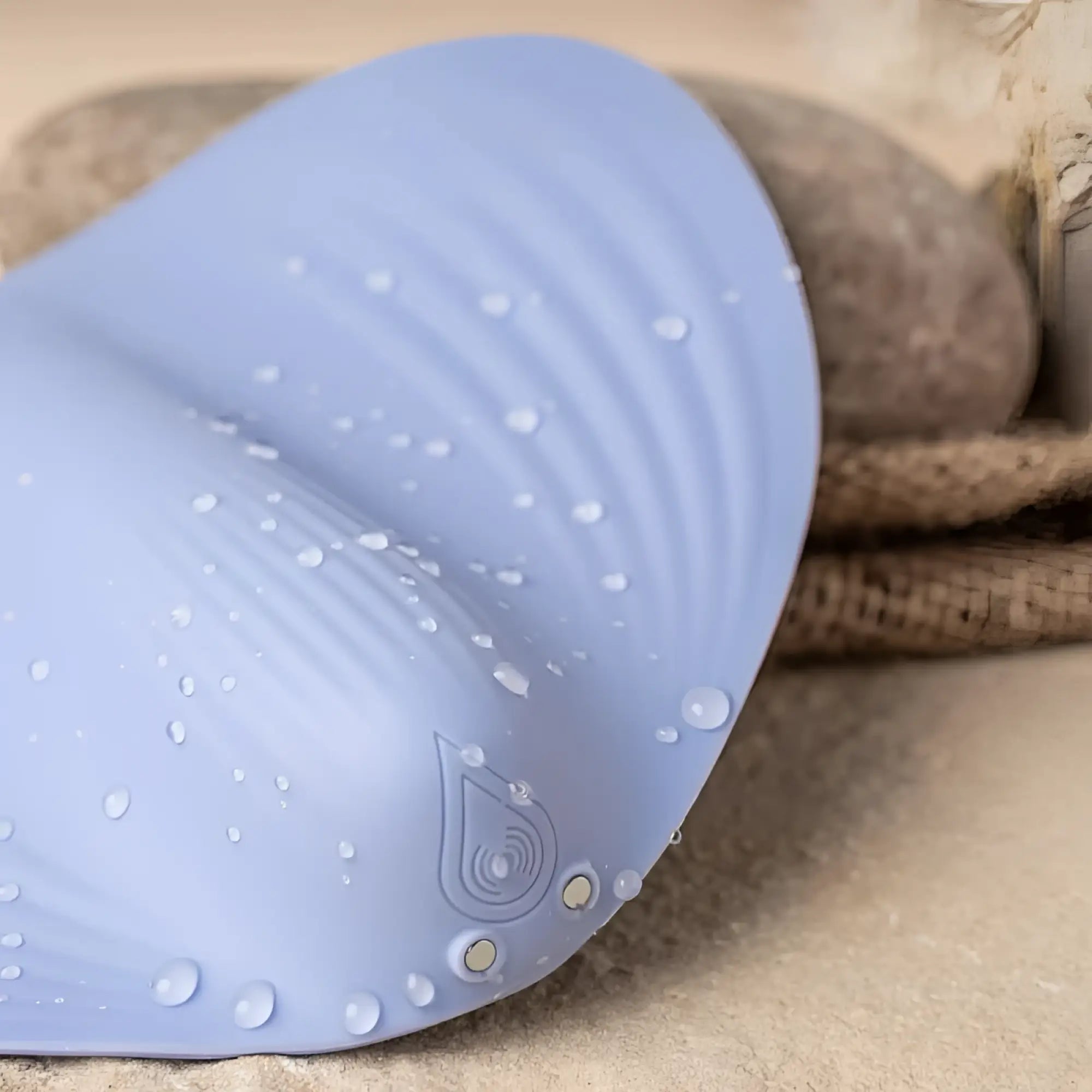 Soft lavender silicone rocks off niya 5 rechargeable massager with subtle wave pattern and water droplets on surface