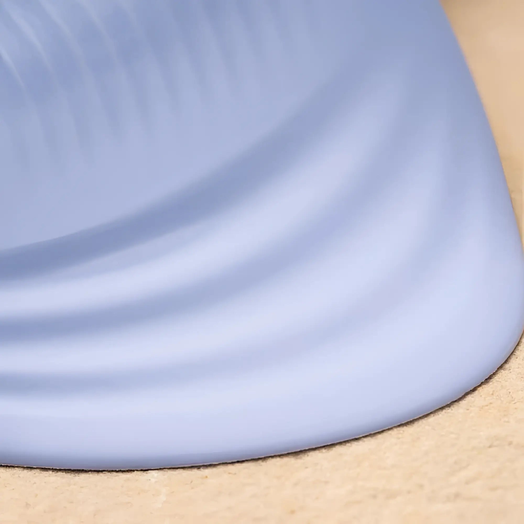 Rocks off niya 5 silicone rechargeable massager with a soft light blue silicone mat featuring curved edge and ribbed texture