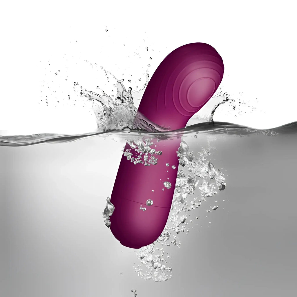 A sleek magenta-colored silicone vibrator with smooth curved design and textured handle rocks off sugarboo berry massager vibe pink