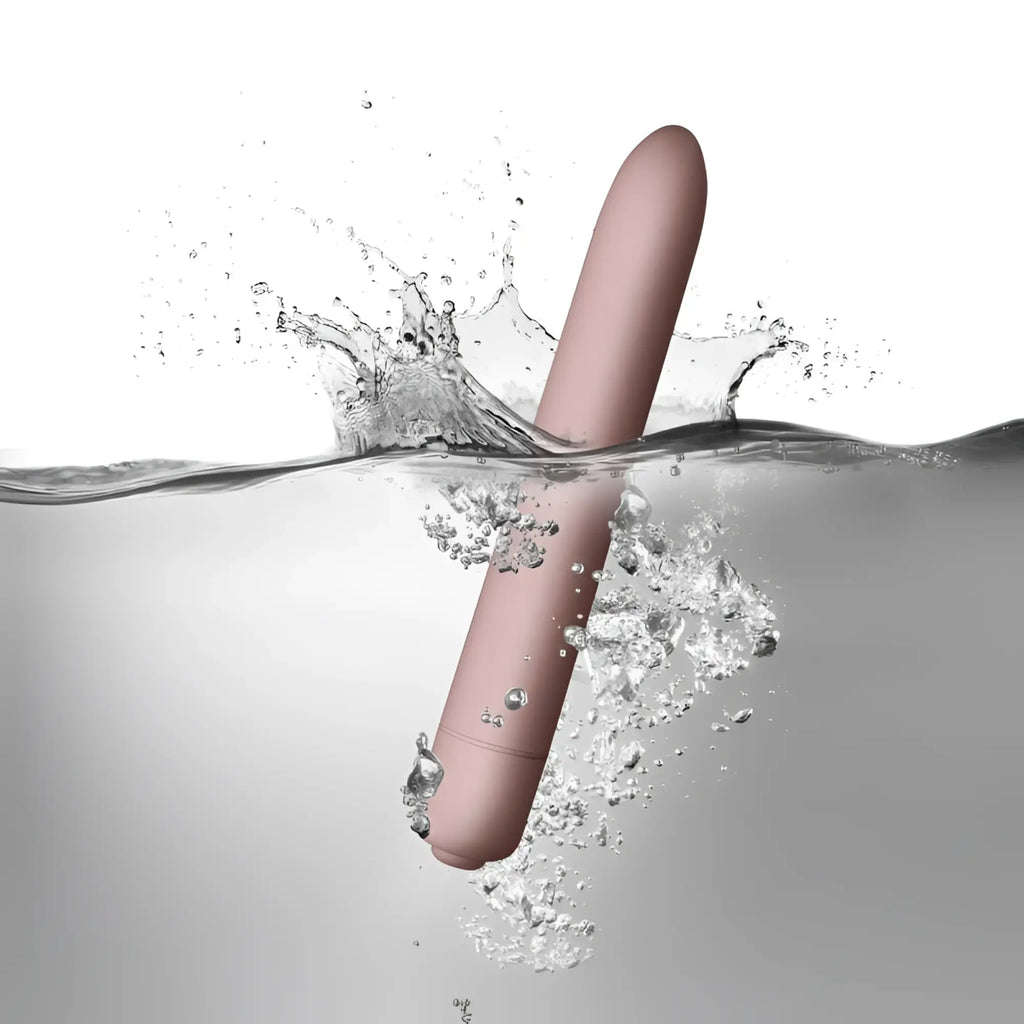 A sleek matte rose gold cylindrical vibrator with smooth rounded design rocks off sugarboo bullet vibe blush