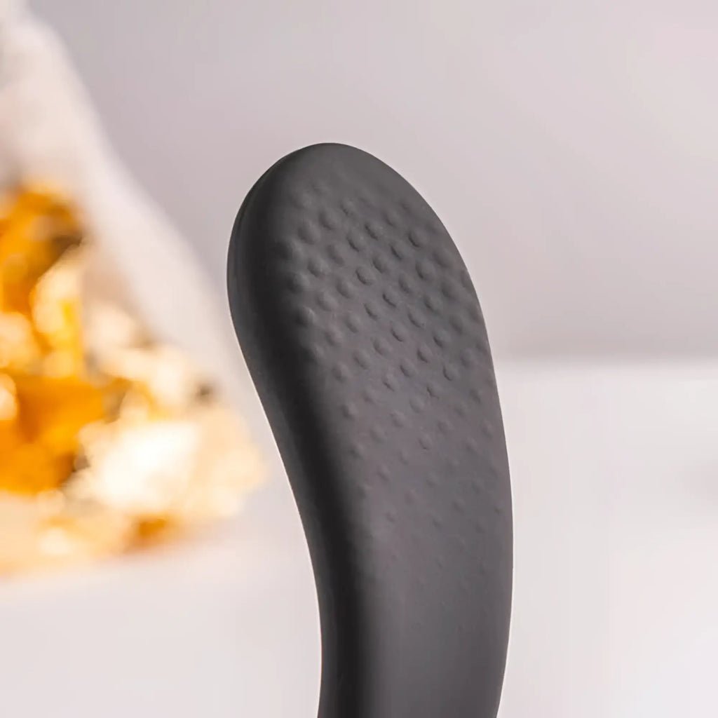 Black silicone spatula with textured non-slip grip surface alongside rocks off the vibe 10 speed remote mens silicone vibrator