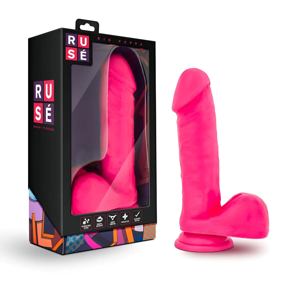 Bright pink silicone dildo from ruse displayed beside its black and colorful packaging for adult use