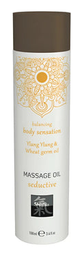 A sleek white cylindrical bottle of shifa massage oil seductive with brown cap and gold mandala design 100ml