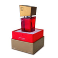 A striking red glass Shiatsu Shiatsu pheromone fragrance woman bottle with a gold and black square cap in branded packaging