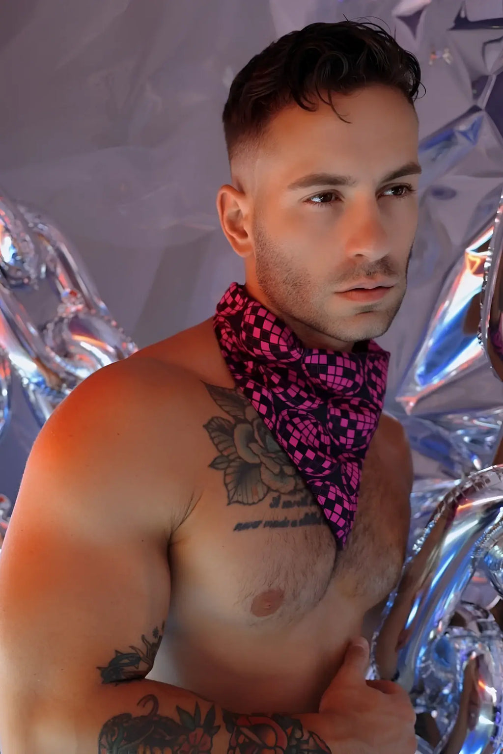 A vibrant pink and black checkered Slay-Kerchief disco ballz bandana worn around the neck for stylish accessory use