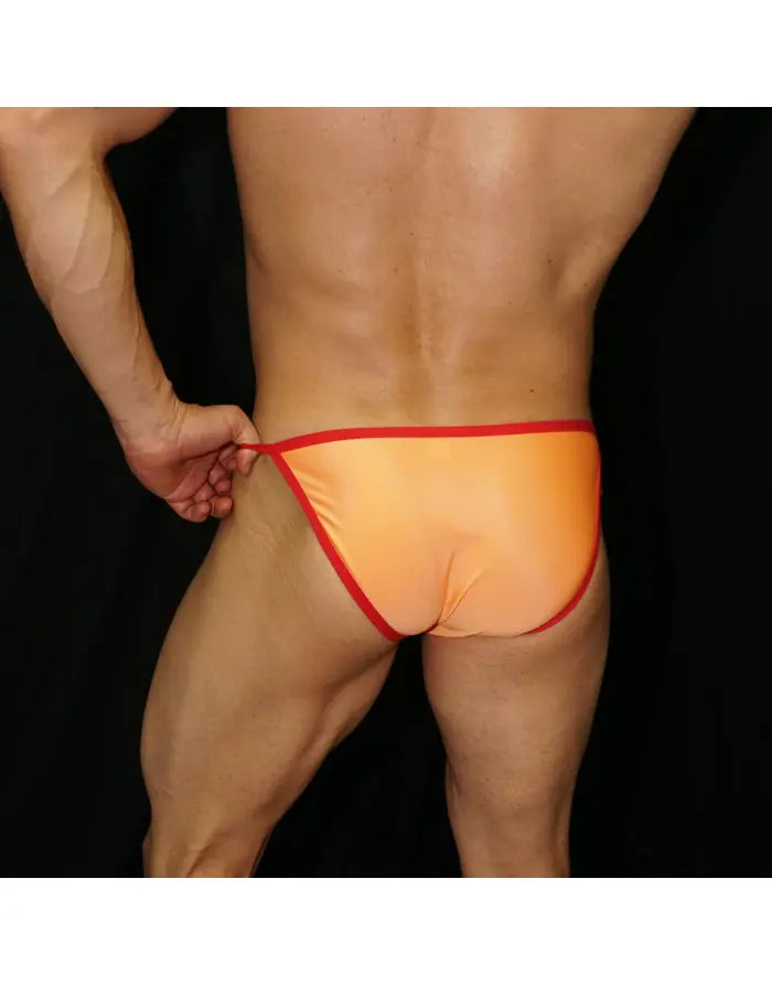 Men's sling bikini in orange and red by Arroyman featuring a low-rise cut and minimal coverage shown from the back.