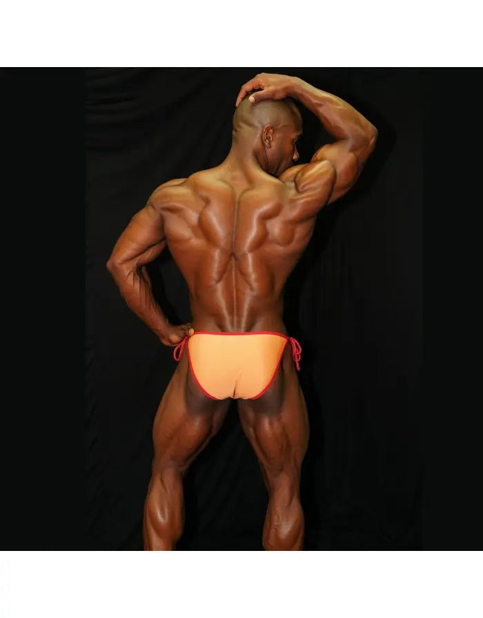 Orange and red sling bikini underwear by Arroyman featuring a low-rise cut and adjustable side ties shown on a muscular model.