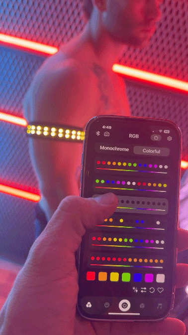 A sleek black soundwave armband smartphone displaying a vibrant rgb color picker interface with sliders and colored squares
