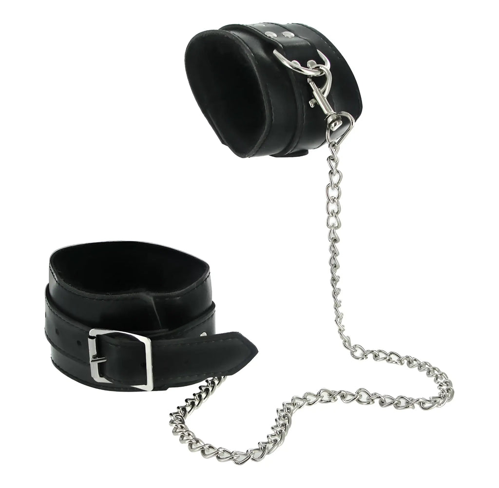 Black leather wrist cuffs with silver metal hardware and chain from the strict 7 pc bondage adventure set