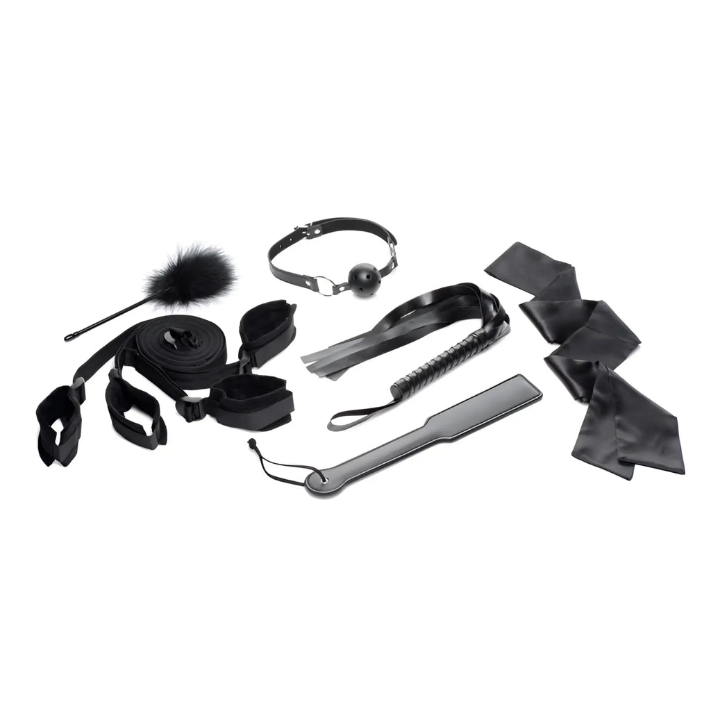 Black leather bondage kit with assorted restraints whip and accessories for strict bed restraint play