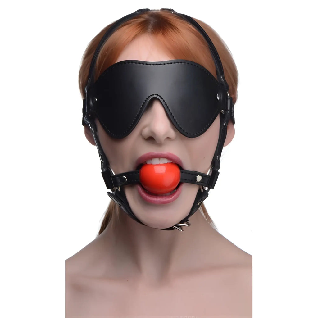 Black leather muzzle with red ball gag designed as a strict blindfold harness for restraint and sensory play