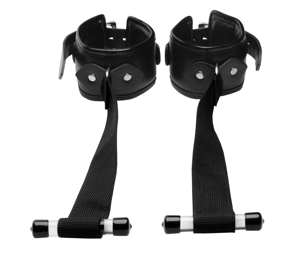 Black leather wrist cuffs with adjustable straps and metal hardware connected by a bar in strict deluxe over the door restraint system