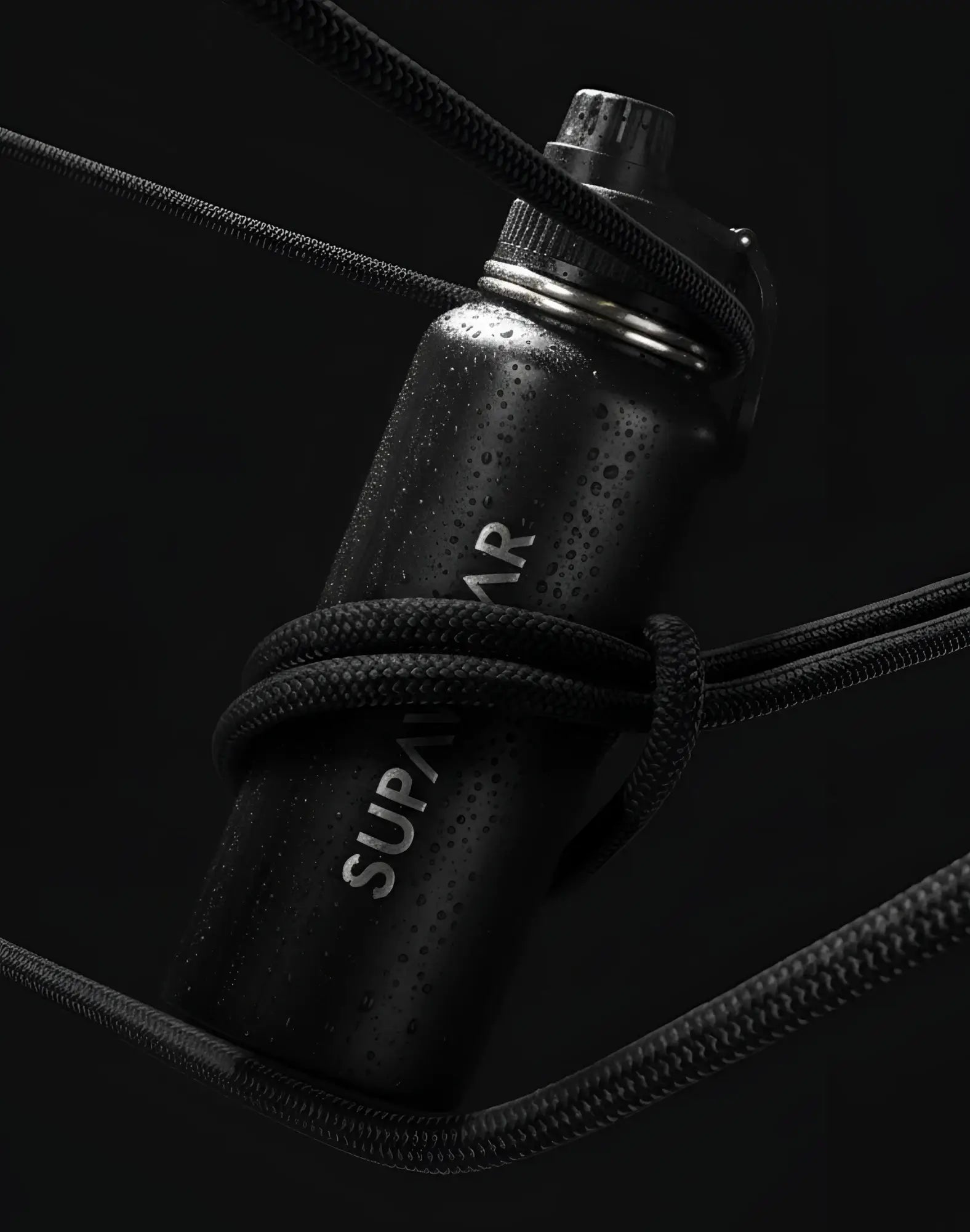 SupaWear 1L black stainless steel water bottle with silver screw-on cap and braided black cord wrapped around body